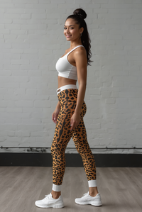Side view of a model showcasing Wild Leopard Print Casual Leggings, perfect for active lifestyles. These high-waist leggings are not only designer leggings but also sport-luxe staples. Engineered to be squat-proof, they provide 4-way stretch and compression support, making them great for gym sessions or relaxing in style as athleisure leggings.