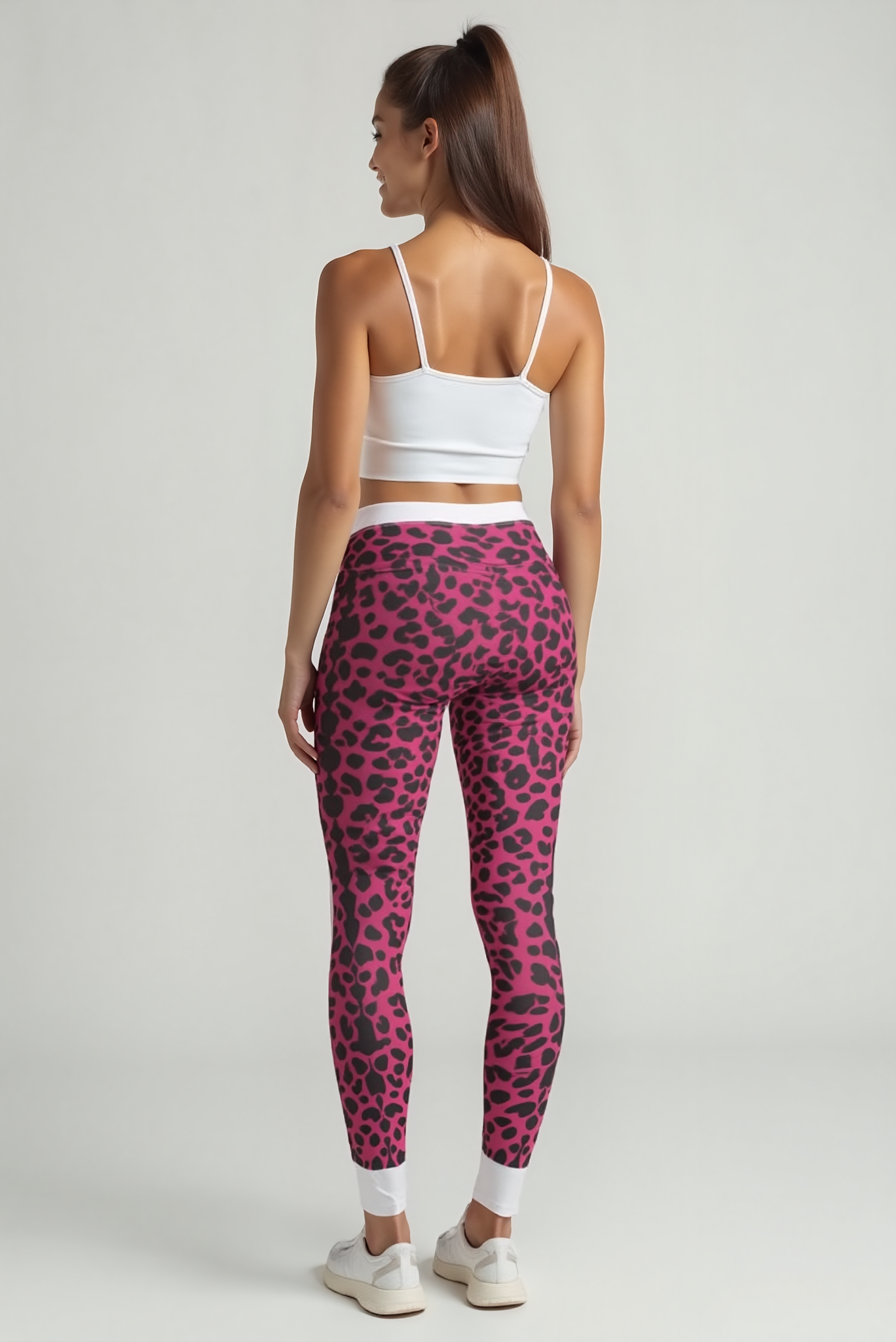 Back view of Women's Pink Leopard Print Leggings showcasing a sleek design. These high-waist leggings serve as statement leggings, embodying the sport-luxe trend. With squat-proof and seamless qualities, they are both gym-ready and stylish for casual outings, making them essential compression and 4-way stretch leggings.