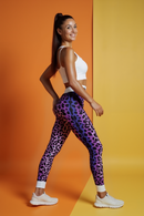 Side view of a model wearing Trendy Women's Animal Print Leggings while striking a pose, emphasizing the bold leopard print design.