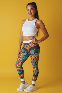 Smiling model in vibrant bohemian print high-waist leggings designed by Christofffe. The athleisure leggings provide a perfect mix of fashion and functionality with their squat-proof design and seamless fit. Ideal for both casual wear and intense workouts, these leggings encompass the essence of statement leggings and gym leggings.