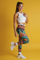 A cheerful model in vibrant bohemian print leggings, embodying a casual yet chic style perfect for festivals or workout sessions. These designer leggings are high-waisted, seamless, and offer excellent compression, making them the go-to sport-luxe leggings for anyone seeking comfort and style in their athleisure wardrobe.