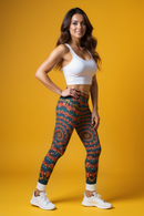 Smiling woman modeling Colorful Bohemian Leggings for Everyday Comfort, Stylish Activewear, Unique Gift Ideas, Festival Wear, Cozy Loungewear against a vibrant yellow backdrop. These sport-luxe leggings are designed for maximum movement with high-waist and squat-proof features, perfect for both the gym and everyday wear.