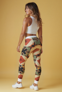 The back view of a model in trendy printed leggings, showcasing their sleek high-waist design. These designer leggings are not only squat-proof but also feature 4-way stretch for enhanced mobility during workouts. Ideal for both fitness enthusiasts and fashion-forward individuals, these sport-luxe leggings bring together comfort and style in one seamless package. The unique pattern and compression fit make them standout choices in athleisure and gym wear.