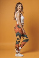 Frau trägt einzigartige Designer-Leggings mit buntem Ethno-Muster, hohe Taille, nachhaltiges Material, ideal für Yoga und Alltag.