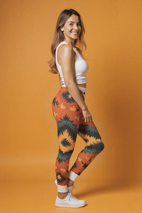 Frau trägt einzigartige Designer-Leggings mit buntem Ethno-Muster, hohe Taille, nachhaltiges Material, ideal für Yoga und Alltag.